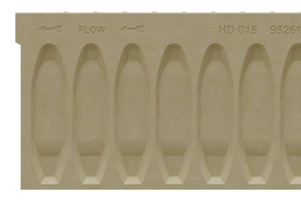 Beige plastic mold with a repeating row of oval cavities and arrows labeled FLOW.
